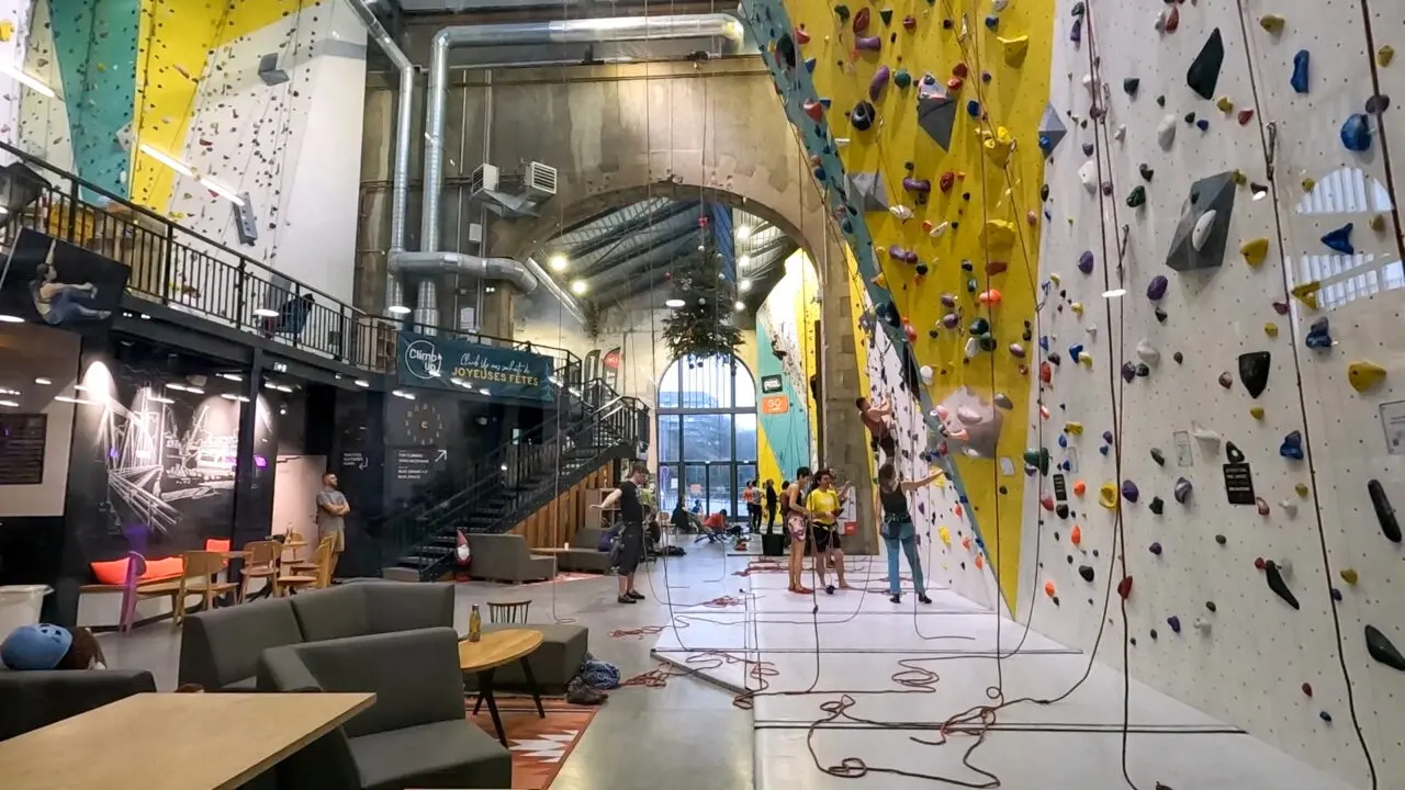 Indoor climbing gym inside Les Ateliers des Capucins with colorful artificial climbing walls and safety equipment