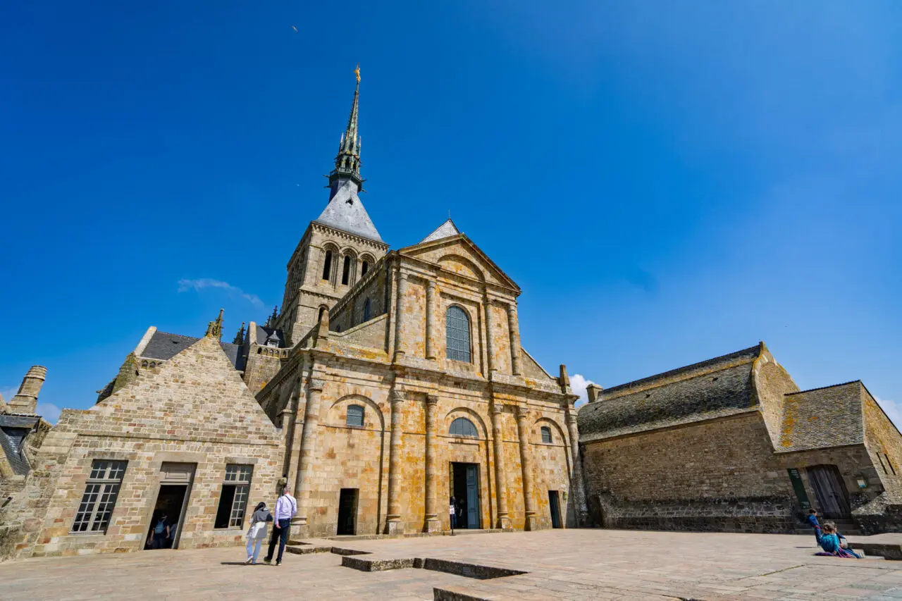 Mont Saint-Michel abbey church facade from West Terrace showing Romanesque architecture and bell tower