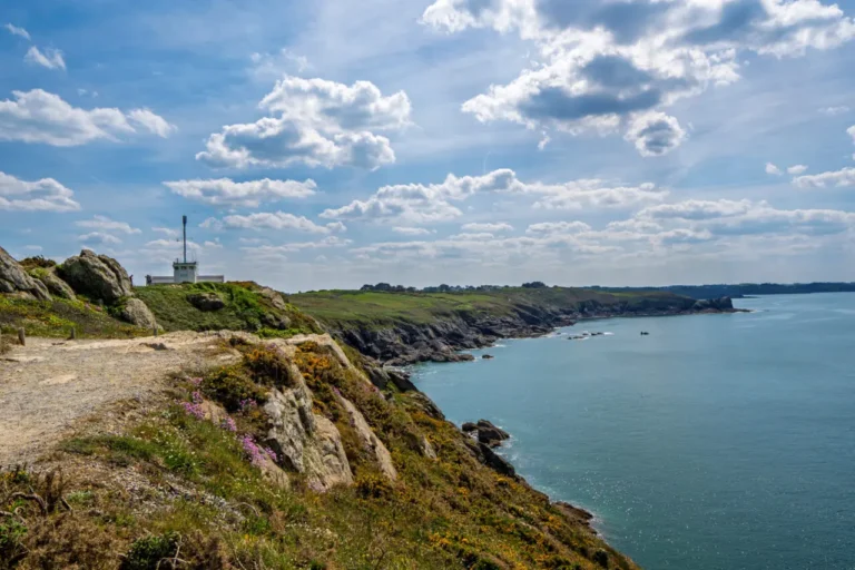 Pointe du Grouin lighthouse and signal station overlooking dramatic Brittany coastline with wildflowers and hiking paths near Cancale, France