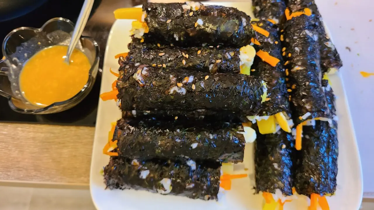 Homemade torn Korean gimbap with mustard sauce served on white plate